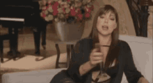 a woman is sitting on a couch holding a glass of champagne .
