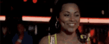 a woman wearing hoop earrings is dancing in a club .