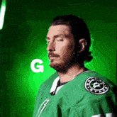 a man in a green jersey with the letter g on the bottom