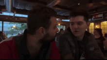 two men are kissing in front of a sign that says ' denver colorado '