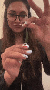 a woman wearing glasses is holding something in her hand with a sticker on her finger that says " i love you "