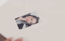 a close up of a person holding a card with a picture of a girl on it