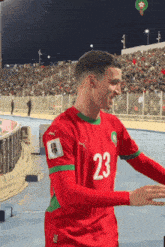 a soccer player wearing a red and green jersey with the number 23 on it