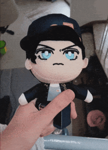 a person is holding a stuffed doll with a hat on