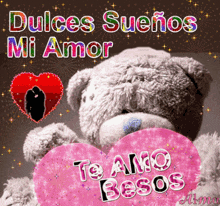 a teddy bear holding a pink heart that says te amo besos on it