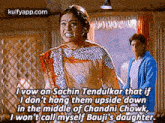 a woman in a sari is talking to a man in a blue jacket in a movie .