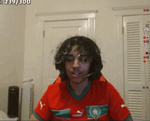 a man wearing a red puma shirt with a microphone on his head