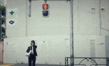 a woman walking in front of a construction site with a green light on