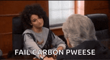 a woman is sitting at a desk talking to a man and the words fail carbon pweese are visible .