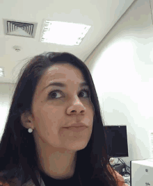 a woman wearing earrings looks at the camera with a serious look on her face