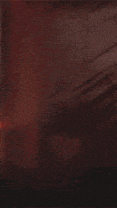 a blurred image of a person 's face with a red and white plaid shirt on