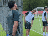 a group of men are standing on a soccer field and one of them has the letter c on his shirt