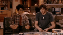 two men are sitting on a couch with a gifwave.com watermark