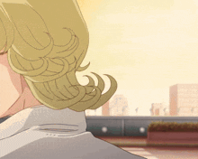 a close up of a woman 's blonde hair with a city background