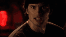 a man in a dark room with a red light behind him