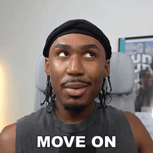 a man wearing a black headband and a tank top says move on