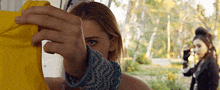 a woman is holding a yellow shirt in front of her face