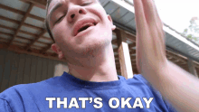 a man in a blue shirt says that 's okay in white letters