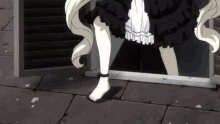 a girl in a black dress is standing barefoot on a brick sidewalk