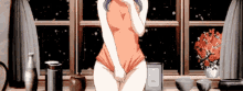 a girl in a bathing suit is standing in front of a window holding her pants up