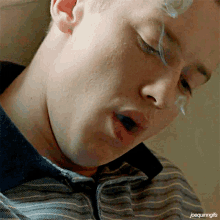 a close up of a man smoking a cigarette with joequininggifs written on the bottom