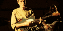 a man is playing a guitar in a band