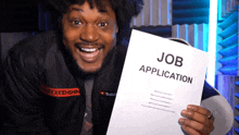 a man holds up a job application in his hand