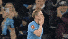 a soccer player in a blue jersey with a sticker on his chest that says ' fc barcelona '