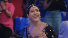 a woman is laughing while sitting in a crowd of people .
