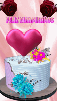 a birthday cake with flowers and a pink heart with the words feliz cumpleanos above it