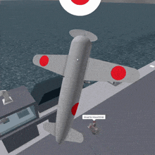 a gray airplane with red circles on the wings and a sign that says head to island b kk