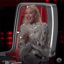 a woman is sitting in a chair with a nbc logo on the back
