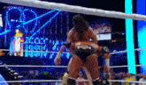 two men are wrestling in a wrestling ring with a crowd in the background .