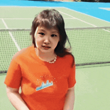 a girl wearing an orange shirt that says adults