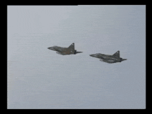 two fighter jets are flying side by side in the air