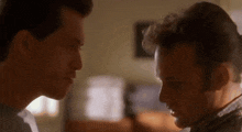 two men looking at each other in a room