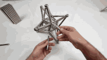 a person is playing with a star made of magnetic sticks