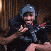 a man wearing headphones and a bulleamy shirt smiles