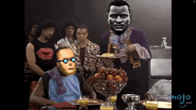 a group of people are gathered around a table with mojo.com written on the bottom of the screen