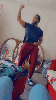 a man in a black shirt and red pants stands in front of a mirror