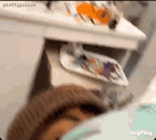 a person is laying on a bed next to a table with a tray of food on it .