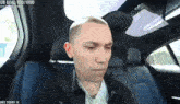 a man is sitting in the back seat of a car with a ub goal of 870/1000