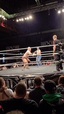 two wrestlers in a ring with a sign that says ' fox ' on it