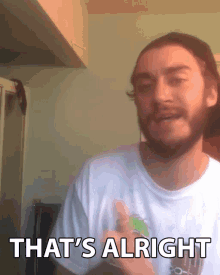 a man with a beard wearing a white shirt that says that 's alright