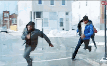 a man in a blue jacket is running in front of a fire hydrant