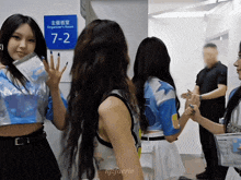a group of girls are standing in front of a blue sign that says organizer 's room 7-2