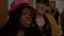 a woman wearing a pink hat points her finger