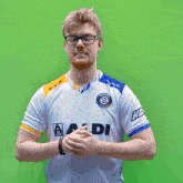 a man wearing glasses and a white shirt with the letter s on it