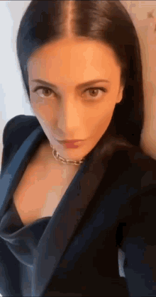 a close up of a woman wearing a black jacket and a black top .