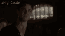 a man in a dark room with #highcastle written on the bottom right